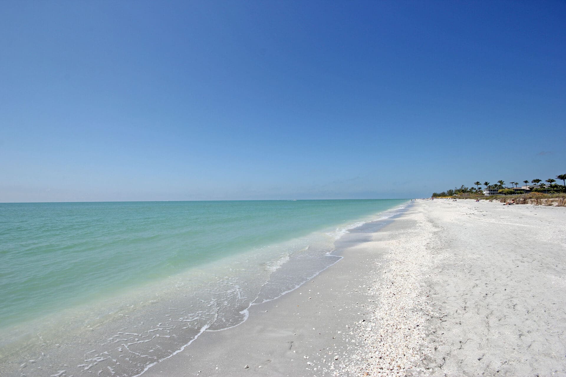 A beach with white sand and blue water