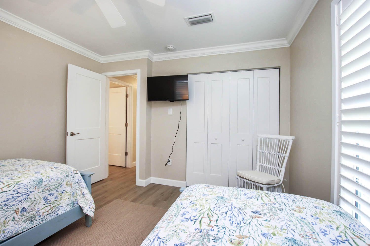 A bedroom with two beds and a television.