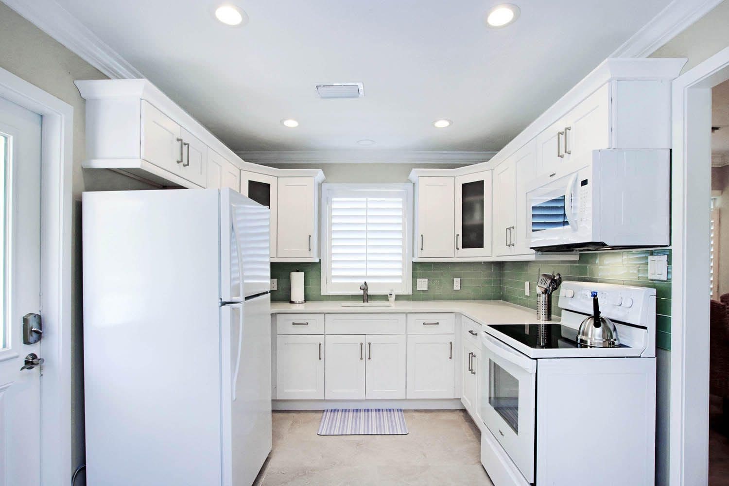 A kitchen with white cabinets and appliances in it