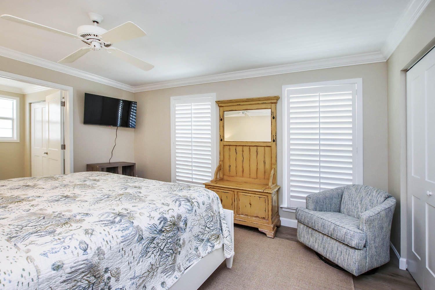 A bedroom with a bed, chair and television.