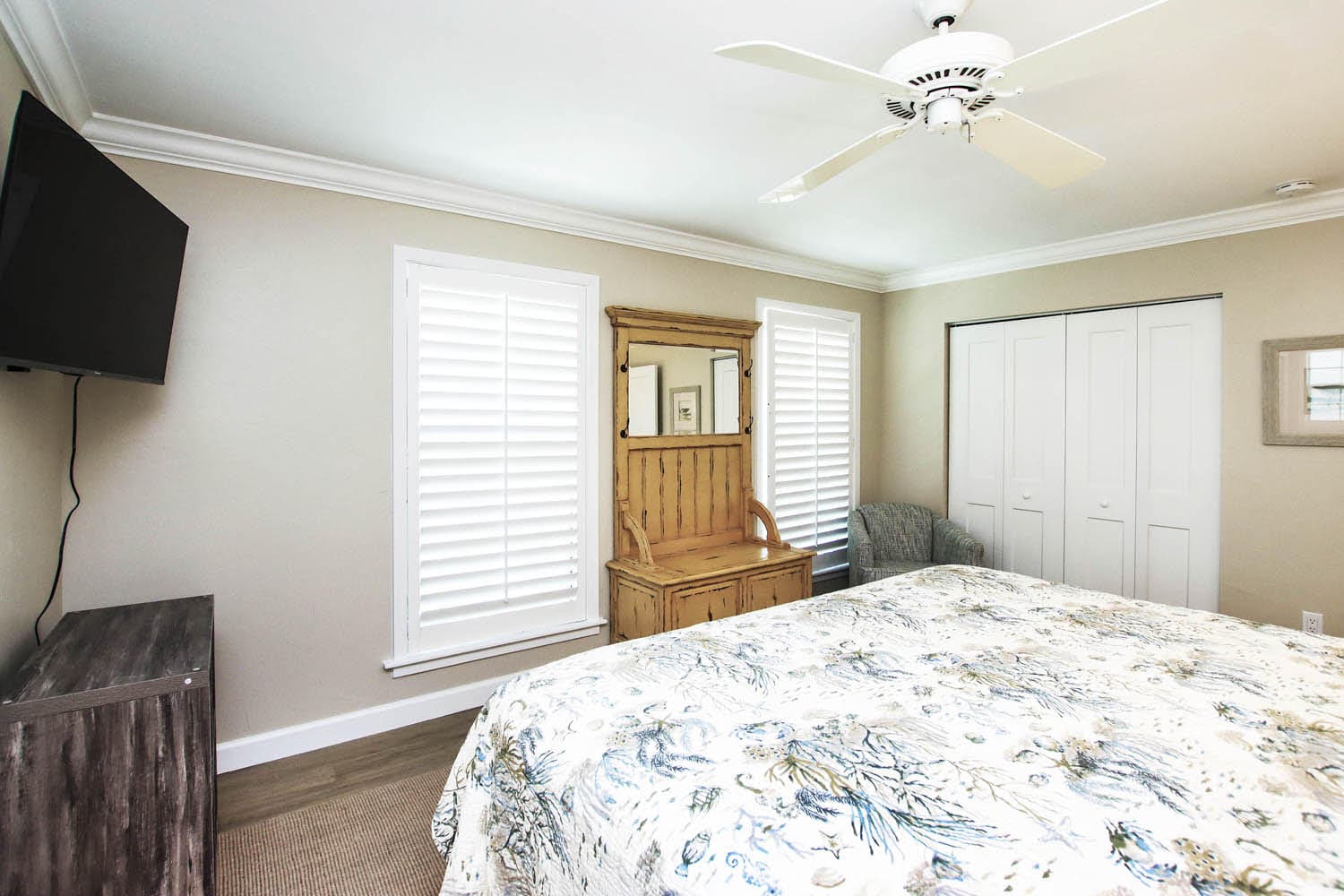 A bedroom with a bed, dresser and window.